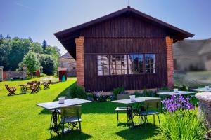 un groupe de tables et de chaises devant un bâtiment dans l'établissement zámek Nemilkov, à Velhartice