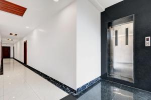 un pasillo con paredes blancas y negras y una puerta blanca en Hotel O Aditya Premier, en Guntūr