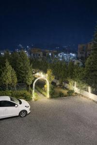 een witte auto geparkeerd op een parkeerplaats 's nachts bij IVY The Boutique Hotel By Backpacker Stop in Nainital