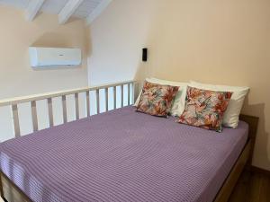 una camera da letto con letto e lenzuola e cuscini viola di Aleminas Rooms 2 a Sými