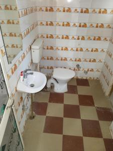 a bathroom with a toilet and a sink at Chaps le guest house in Patna