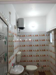 a bathroom with a toilet and a sink at Chaps le guest house in Patna +2 photos