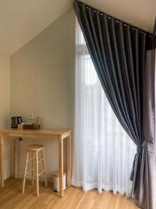 een kamer met een gordijn, een tafel en een raam bij Miramalin Resort Krabi in Ao Nang Beach