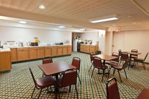 a conference room with tables and chairs and a kitchen at Baymont by Wyndham Lake George in Lake George