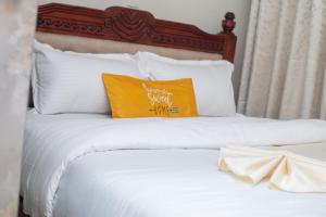 ein Bett mit einem gelben Kissen darauf in der Unterkunft Serene Stays in Naivasha