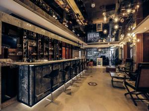 a bar with a black marble counter and chairs at 3 Door Hotel in Tainan