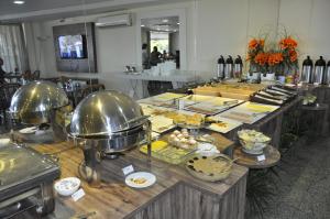 フォルタレザにあるSeaflats Iracema Residenceのレストランのテーブルに並べられたビュッフェ形式の食事