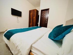 1 Schlafzimmer mit 2 weißen Betten und blauen Kissen in der Unterkunft Hotel Stay Inn in Sohāna