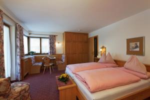 a hotel room with a bed and a desk at Garni Raetia in Corvara in Badia