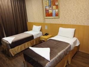 una camera d'albergo con due letti e uno specchio di فندق رمال الخليج a Quai