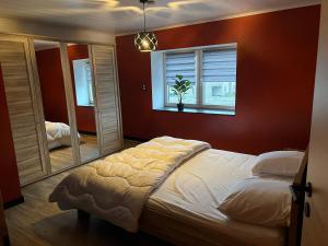 een slaapkamer met een groot bed en een raam bij Le repaire de la n4 in Tenneville