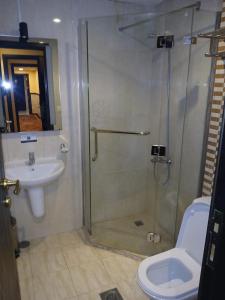 a bathroom with a shower and a toilet and a sink at فندق رمال الخليج in Makkah