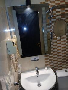 a bathroom with a sink and a mirror and a toilet at فندق رمال الخليج in Makkah