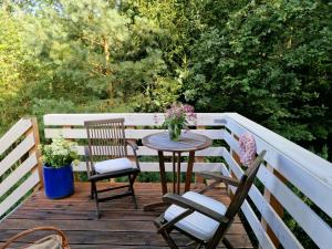 Ein Tisch und zwei Stühle auf einer Holzterrasse in der Unterkunft Wohnung Adlerhorst in Eversen-Heide in Eversen