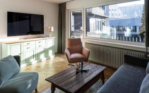 een woonkamer met een bank, een stoel en een tafel bij Das Nordberg Guesthouse in Garmisch-Partenkirchen