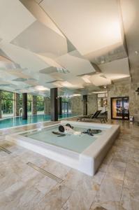 a swimming pool in a large room with a large ceiling at Diune Resort by Zdrojowa in Kołobrzeg