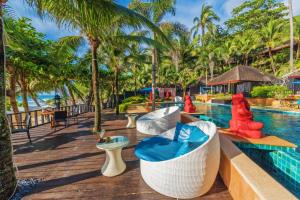 ośrodek z basenem i palmami w obiekcie Andaman White Beach Resort - SHA Plus w mieście Nai Thon Beach