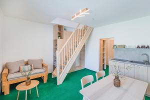 a living room with green flooring and a staircase at Hotel Rusava 2 depandance in Rusava