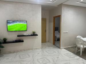 een woonkamer met een televisie aan de muur bij Luxury University Apartment 3 in Fès