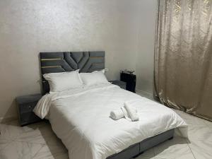 een bed met twee witte slippers erop bij Luxury University Apartment 3 in Fès