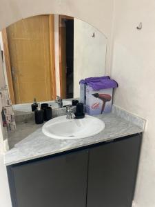 een badkamermeubel met een wastafel en een spiegel bij Luxury University Apartment 3 in Fès