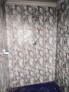 a tiled wall in a bathroom with a shower at ALMiRTY GUEST HOUSE in Grasmere