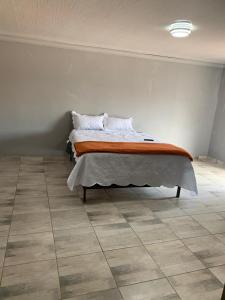 a bed in a room with a tiled floor at ALMiRTY GUEST HOUSE in Grasmere