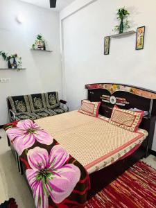 a bedroom with a bed with pink flowers on it at Next Home Stay in Nalkhera