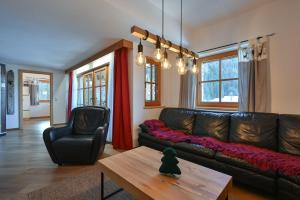 een woonkamer met een leren bank en een salontafel bij Braito's Seaside Lodges und Suites, Ferienhäuser und Ferienwohnungen in Haldensee +54 foto's