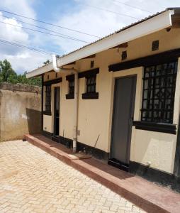 BungomaMiranda suites的一栋有门和砖砌车道的小房子