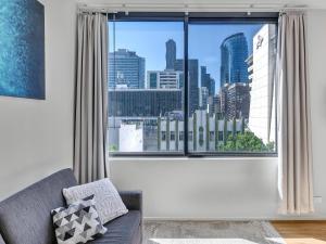 een woonkamer met een groot raam met uitzicht op de stad bij Serenity One Boutique in Melbourne