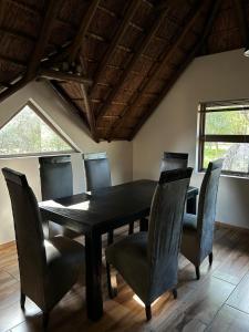een eetkamer met een zwarte tafel en stoelen bij Harties Safari View in Hartbeespoort +28 foto's