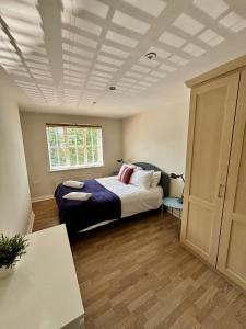 En eller flere senge i et værelse på Woking 2-Bed Flat with Balcony, En-Suite and Parking
