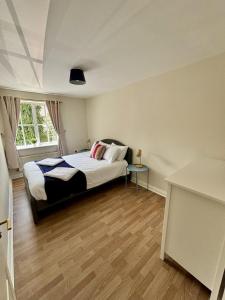 En eller flere senge i et værelse på Woking 2-Bed Flat with Balcony, En-Suite and Parking