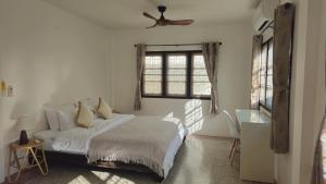 ein weißes Schlafzimmer mit einem Bett und einem Fenster in der Unterkunft 2Bedrooms Beachfront House with Fast WIFI in Nathon Bay