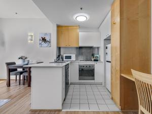 een keuken met witte apparatuur en een tafel in een kamer bij Serenity One Boutique in Melbourne