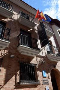 a building with a flag hanging from the side of it at Hotel Complutense in Alcalá de Henares