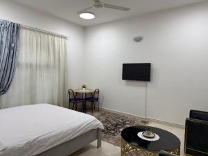 een slaapkamer met een bed, een tv en een tafel bij Mira in Muscat