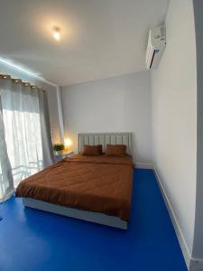 1 dormitorio con 1 cama en una habitación con suelo azul en New Land Hostel, en Kaôh Rŭng (3)