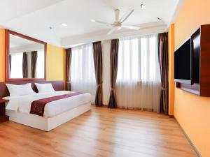 a bedroom with a bed and a flat screen tv at OYO 90630 Mat Leon Village in Kuala Tahan