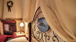 a room with a bed with a curtain and a fireplace at Valentini Guesthouse in Karpenisi