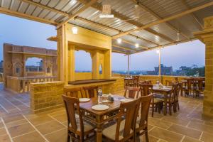 a restaurant with tables and chairs on a patio at Hotel Rugh Niwas in Jaisalmer