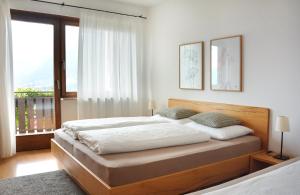 een slaapkamer met een bed en een groot raam bij Appartement Karnutsch in Schenna