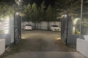 een poort naar een oprit met twee geparkeerde auto's bij IVY The Boutique Hotel By Backpacker Stop in Nainital