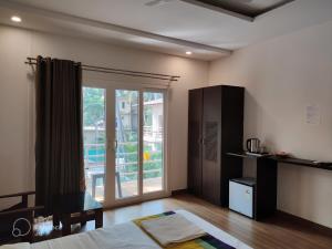 ein Schlafzimmer mit einem Bett und einer Glasschiebetür in der Unterkunft La Volga Beach Resort in Chopdem