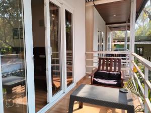 eine abgeschirmte Veranda mit einem Stuhl und einem Tisch in der Unterkunft La Volga Beach Resort in Chopdem