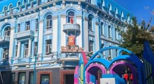 a large blue building with a red sign on it at Jinjiang Inn Select Harbin Zhongyang Street Pedestrian Street Airport Bus Station in Harbin