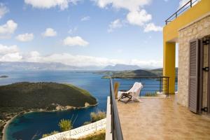 ein Balkon mit Stuhl und Blick aufs Wasser in der Unterkunft marmar lefkada luxury villas in Vlikhón