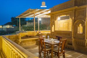 a restaurant with a table and chairs on a roof at Hotel Rugh Niwas in Jaisalmer
