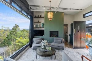 een woonkamer met een bank en een tafel bij Escape to Serenity in Beechmont Luxurious Cabin Retreat in Beechmont